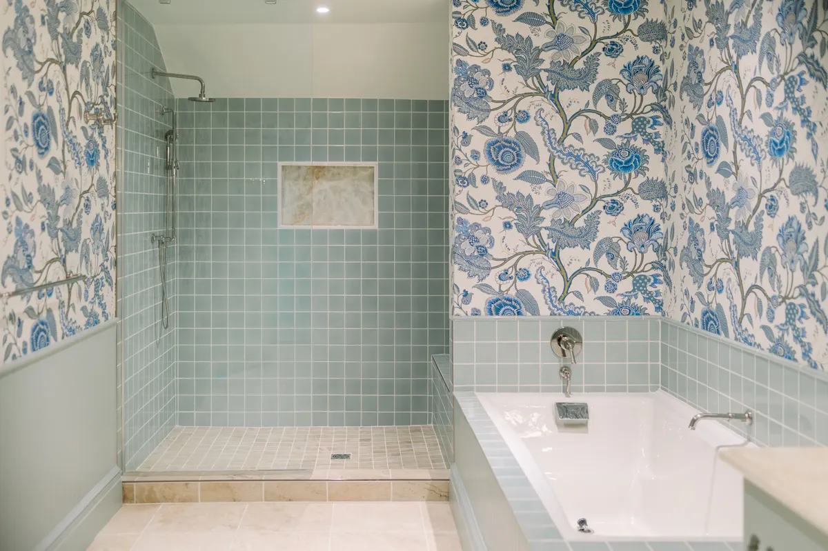 A sophisticated bathroom interior featuring a modern soaking tub and a spacious walk-in shower, complemented by elegant decorative wallpaper. The serene atmosphere is enhanced by soft lighting and refined décor, creating a truly spa-like environment ideal for relaxation and rejuvenation.